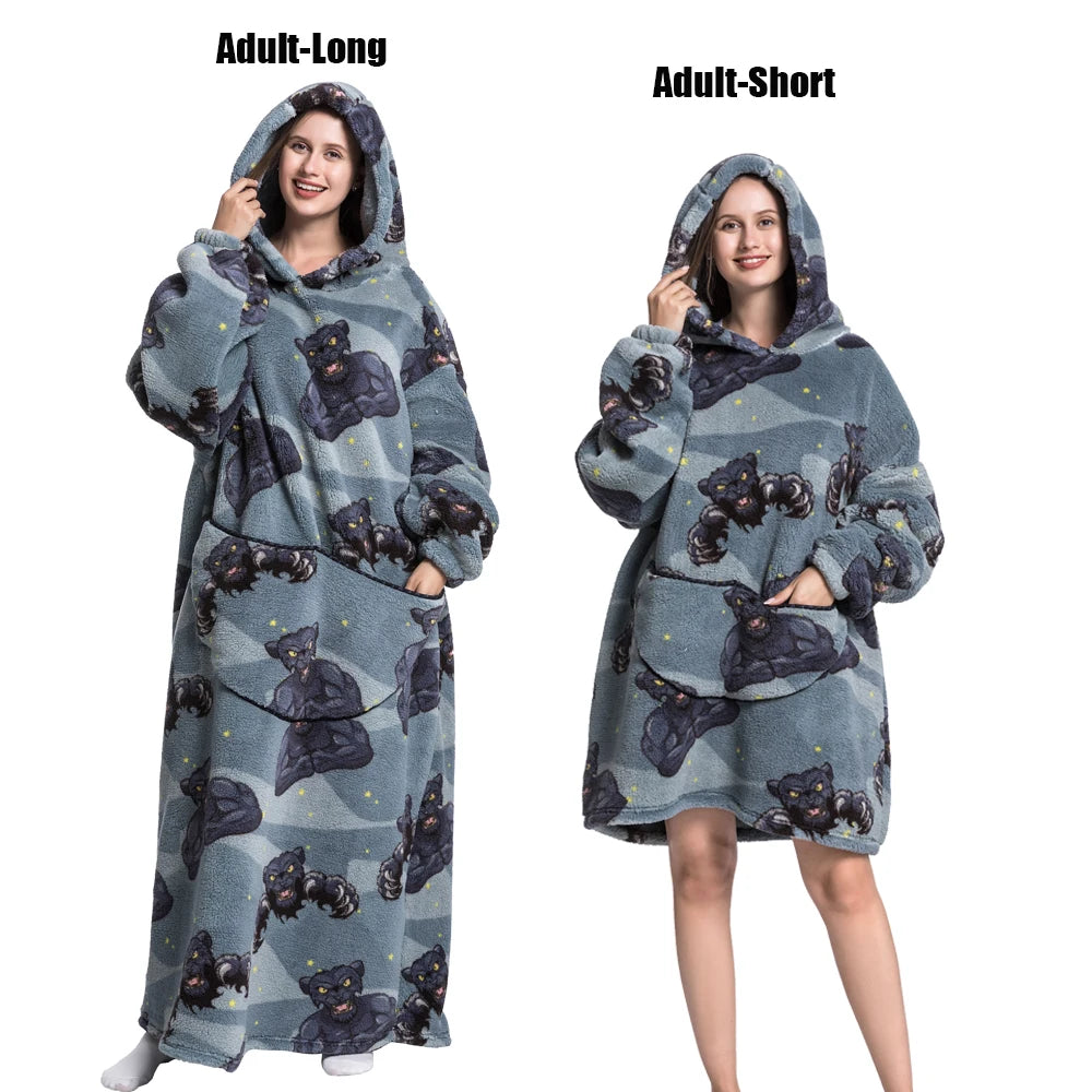 A woman models an Adult-Long and Adult-Short plush fleece blanket hoodie in gray with a dark pattern.