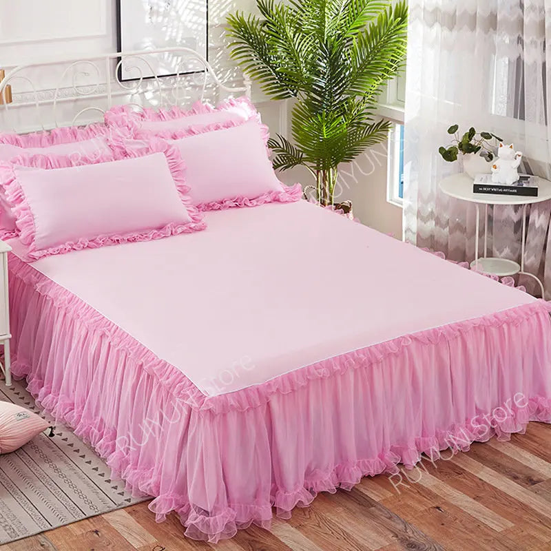 Pink princess lace bed skirt set with pink bedding and greenery in a bright room