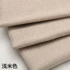 Stacked beige coarse linen and cotton fabric rolls