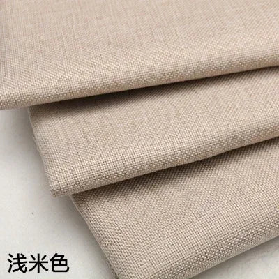 Stacked beige coarse linen and cotton fabric rolls
