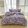 A floral print duvet cover set featuring purple and pink flowers on a dark blue background displayed on a bed.