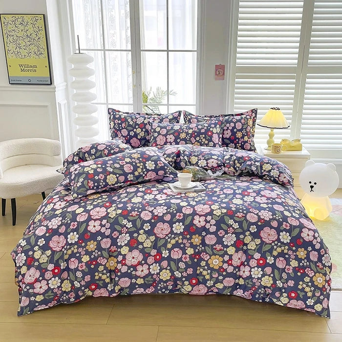 A floral print duvet cover set featuring purple and pink flowers on a dark blue background displayed on a bed.
