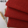 Three folded pieces of coarse red linen or cotton fabric for DIY projects