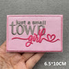 Pink embroidered patch with the text Just a small town girl in gray and pink thread
