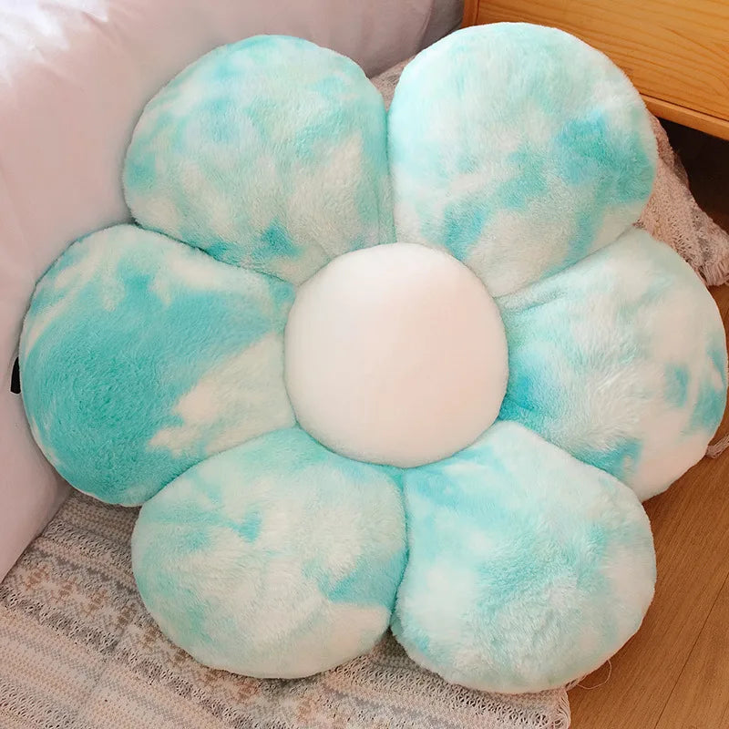 A cluster of light blue and white fluffy sunflower plush flower cushions resting on a light-colored fabric.