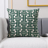 A square lumbar pillow cover featuring a geometric pattern in dark green and off-white tones.