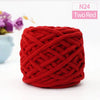 A ball of two-red chunky velvet knitting yarn with an intricate crisscross knit pattern.