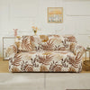 A beige stretch floral elastic sofa cover featuring brown and gold leaf patterns on a light-colored sofa.