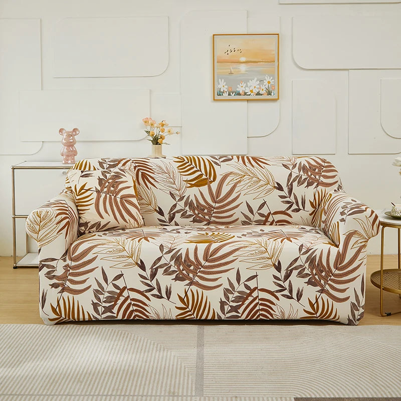 A beige stretch floral elastic sofa cover featuring brown and gold leaf patterns on a light-colored sofa.