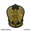 Black embroidered patch featuring a golden winged figure with a sword and the text St Michael Protectus