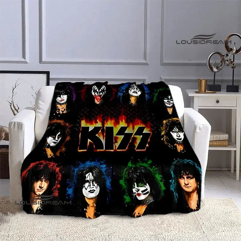 A black printed flannel travel blanket featuring various stylized faces and the word KISS