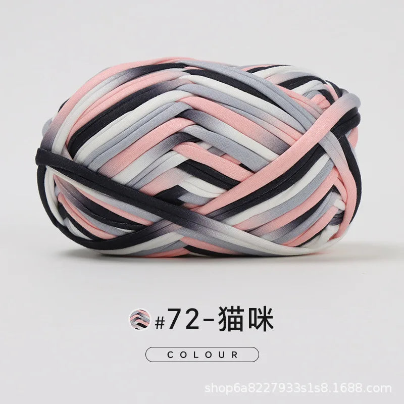 A ball of hand-dyed fabric strip yarn featuring stripes of black, gray, and pink.