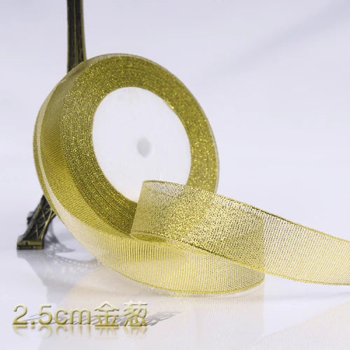A roll of gold glitter organza ribbon used for gift wrapping and DIY crafts.