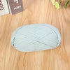 Light blue flat thread yarn skein lying on a wooden surface.