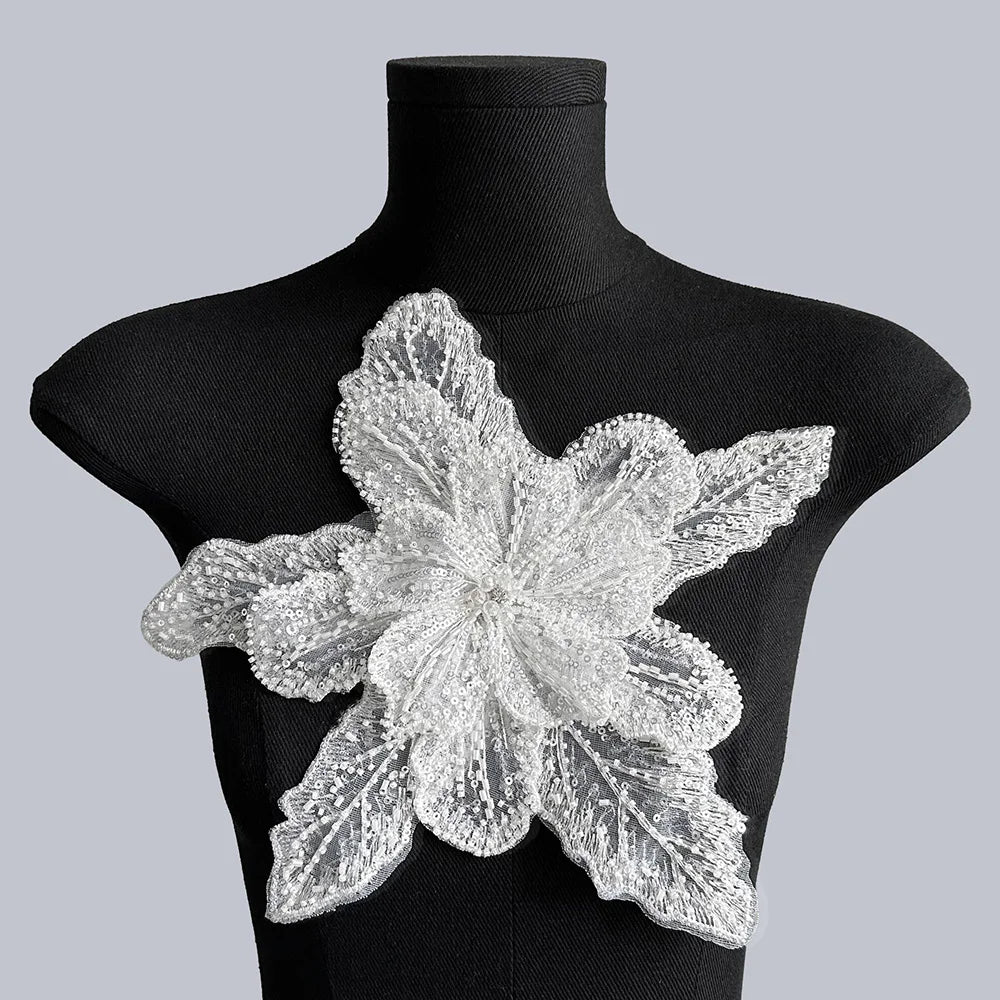 Silver floral lace applique fabric patches displayed on a black mannequin.