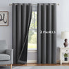 A set of two dark gray blackout grommet curtains hanging in a window frame.