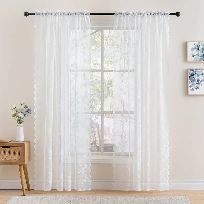 White vintage floral lace curtain panel hanging over a window.