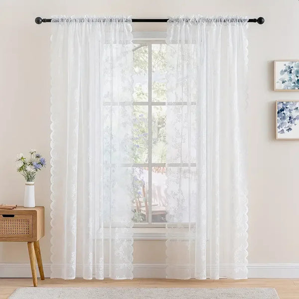 White vintage floral lace curtain panel hanging over a window.