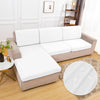 A beige sofa is covered with white waterproof cushion protector covers on a wooden floor.