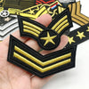 A set of embroidered tactical clothing patches featuring gold and black chevron designs.