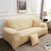 A light beige elegant faux silk sofa cover displayed on a modern sofa in a well-lit room.