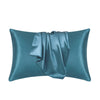 A teal satin silk pillow cover with a draped fabric detail.