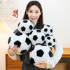 A woman holds a cluster of realistic black and white football plush toys.