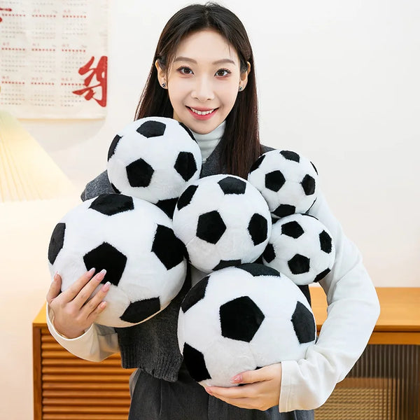 A woman holds a cluster of realistic black and white football plush toys.