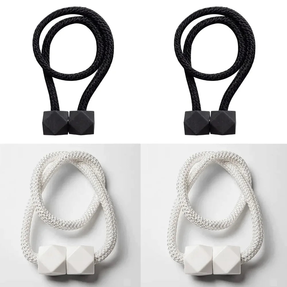 A set of four black magnetic curtain tiebacks, including two looped and two square-shaped.