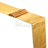 A golden satin table runner draped with a folded fabric on a white background.