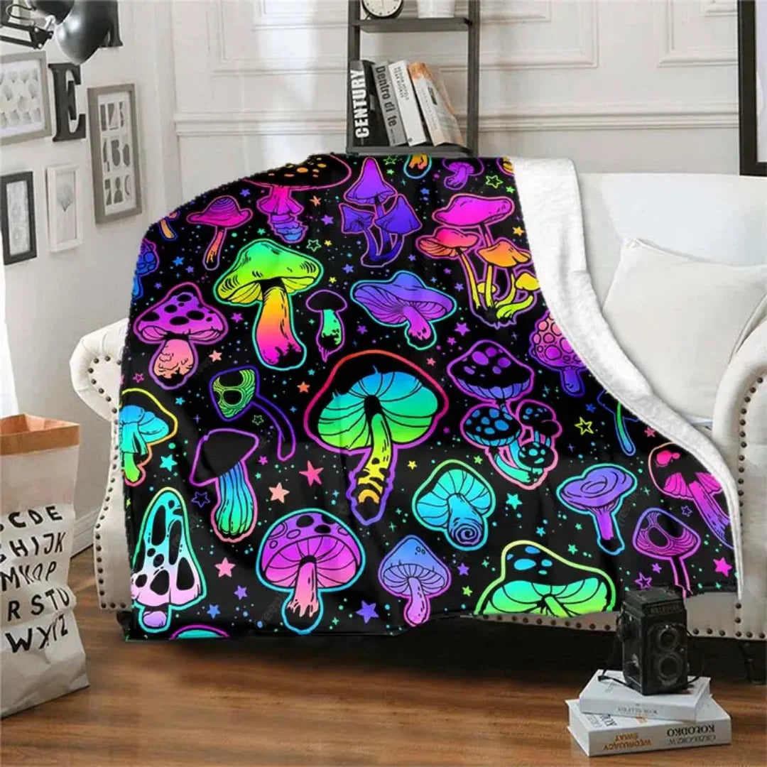 A colorful mushroom flannel throw blanket displayed on a white sofa.