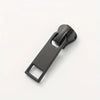 A black universal replacement zipper slider for clothing.