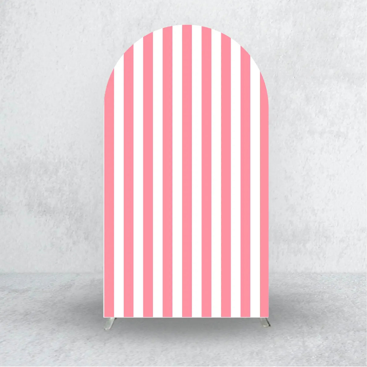A vertical arch backdrop cover with vertical pink and white stripes against a gray concrete wall.