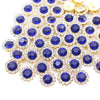 A cluster of blue and clear crystal rhinestone buttons on a gold-toned setting.