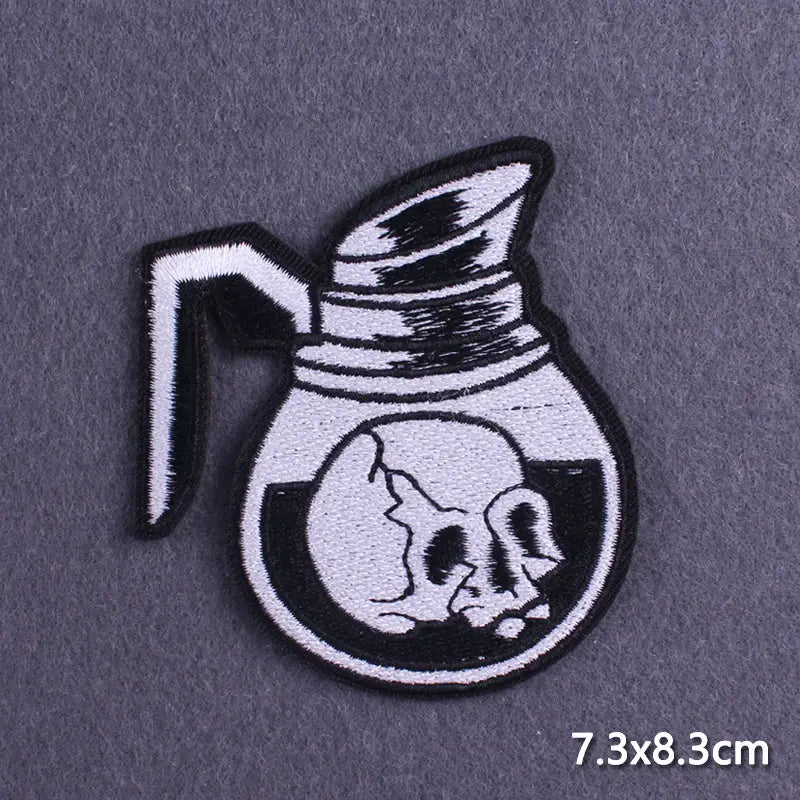 Black and white embroidered patch of a skull in a pitcher design