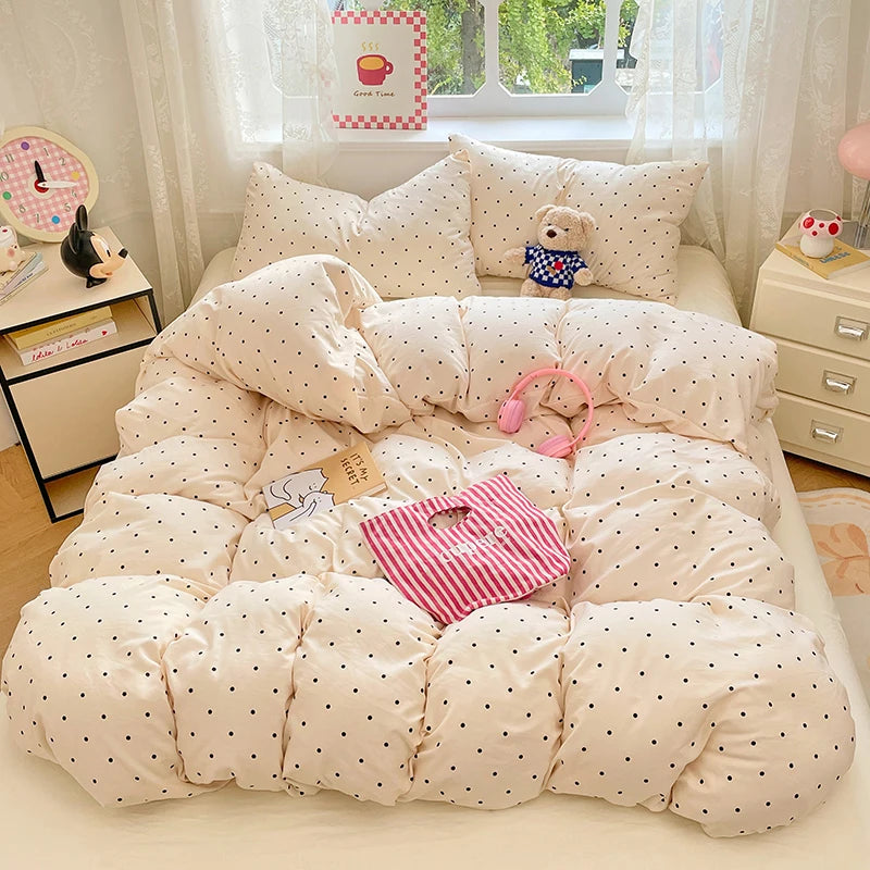 A set of ultra-soft microfiber duvet covers and pillowcases in a cream color with small black polka dots.