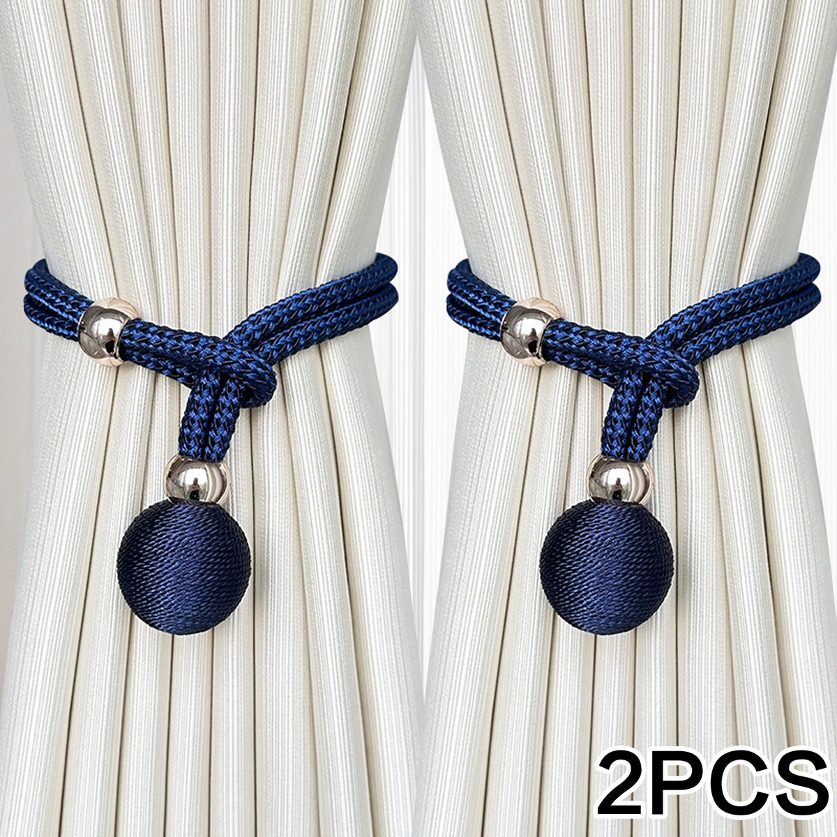 Two navy blue fabric tiebacks with silver accents shown against a cream curtain.