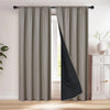 A floor-length gray blackout curtain with a black diagonal panel hanging in a window frame.
