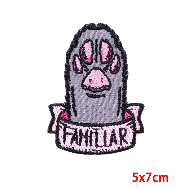 A dark gray embroidery patch depicting a stylized rose skull face with pink accents.