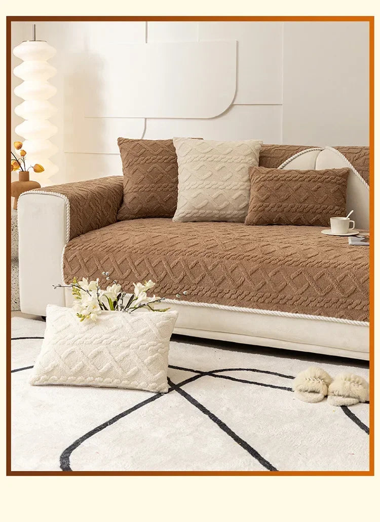 A brown plush sofa cushion cover with cream accent pillows and a white textured rug.