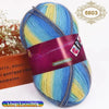 A ball of gradient dyed wool yarn featuring blue, yellow, and green stripes, packaged with a label.