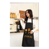 A woman wearing a black waterproof oil-proof PVC kitchen apron while cooking in a kitchen setting.