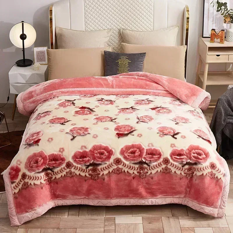 A pink and cream floral patterned weighted blanket displayed on a bed with light wood furniture.