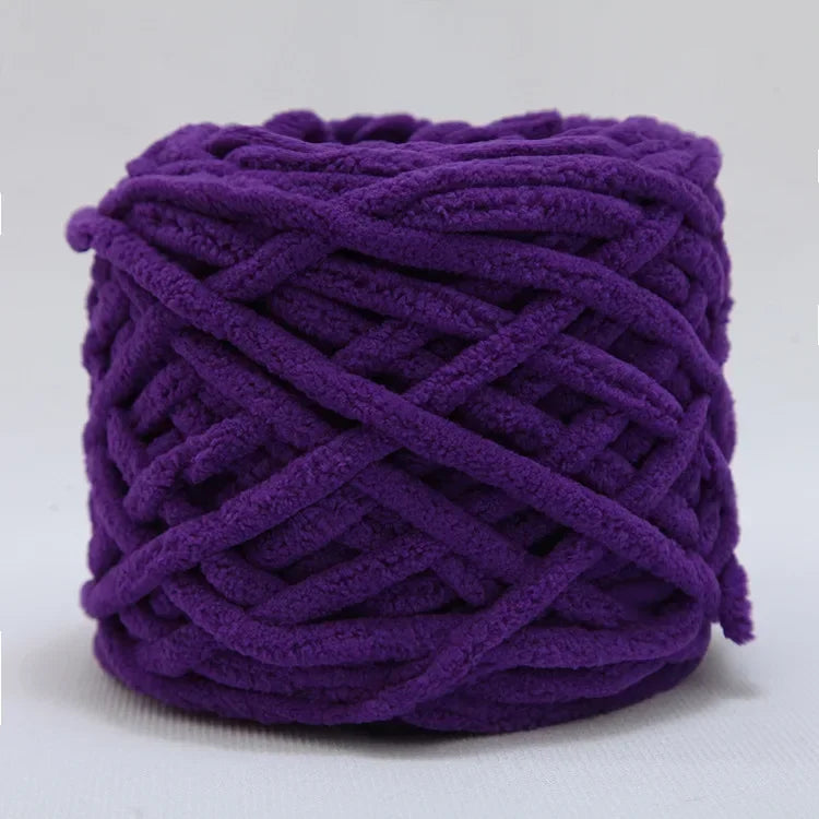 A ball of purple chenille knitting yarn used for hand crafting.