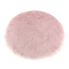 A round, plush, pink faux fur sheepskin area rug.