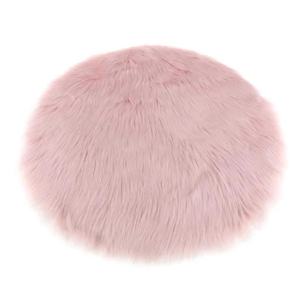 A round, plush, pink faux fur sheepskin area rug.
