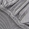 Close-up of a gray jacquard stretch sofa cover with gathered fabric texture.