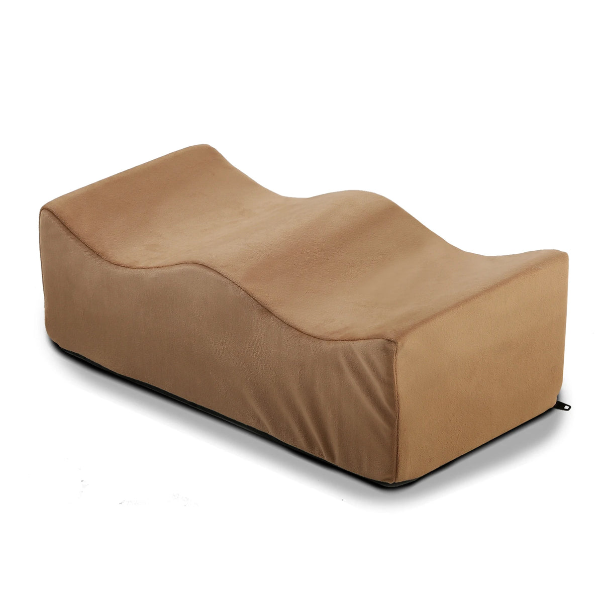 A tan ergonomic memory foam leg support pillow shown from the side.