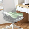 A light gray ergonomic memory foam seat cushion with a green backrest is shown on a white office chair.