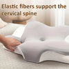 A hand is adjusting a white memory foam contour neck pillow on a light-colored surface.